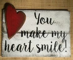 a wooden sign that says you make my heart smile with a red heart on it