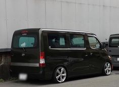 a black van parked in front of a building next to another car on the street