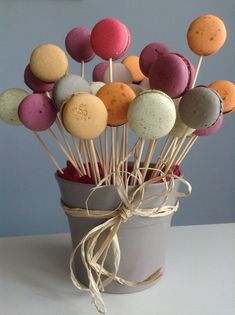 a cup filled with lots of different flavored donuts on top of sticks next to a wall