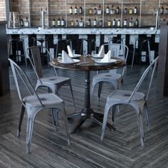 a table with four chairs around it in front of a wine rack filled with bottles