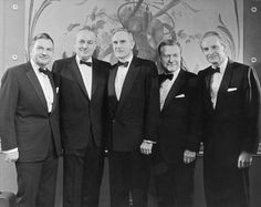 a group of men in tuxedos posing for a photo