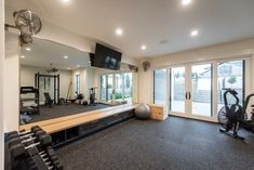 a home gym with exercise equipment and sliding glass doors