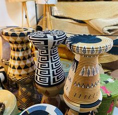 several baskets are stacked on top of each other in different colors and patterns, including black, white, blue, yellow and green