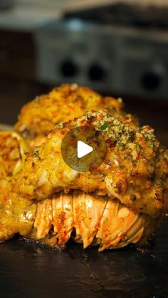 two cooked lobsters on a cutting board with cheese and seasoning sprinkles