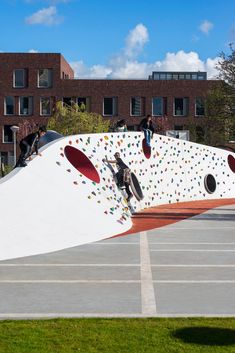 skateboarders are riding on the side of a white ramp with colorful circles and dots