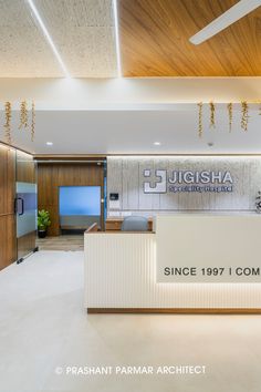 the front desk of an office with lights hanging from it's ceiling and wood paneling