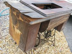 an old wooden box sitting on top of gravel