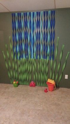 a room with green walls and blue wavy curtains on the wall, two children's toys in front of them