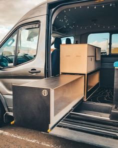 a van with the door open and boxes in it's cargo compartment on the side