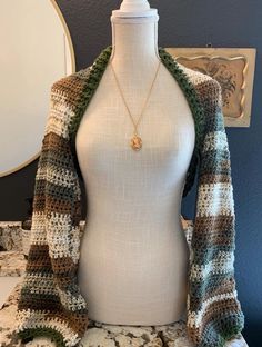 a mannequin with a sweater on top of it and a necklace hanging from the neck