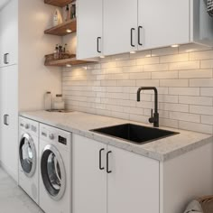 a laundry room with white cabinets and washer and dryer