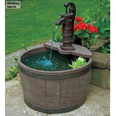 a water fountain is shown in the middle of a flower pot with flowers around it