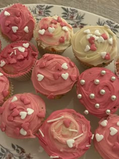 cupcakes with pink frosting and white sprinkles on a plate