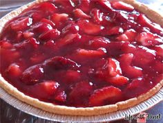 a pie with strawberries on it sitting on a table