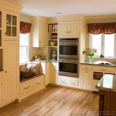 a kitchen with wooden floors and white cabinets