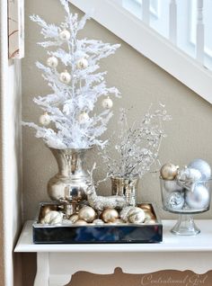 a white christmas tree sitting on top of a table next to a bannister