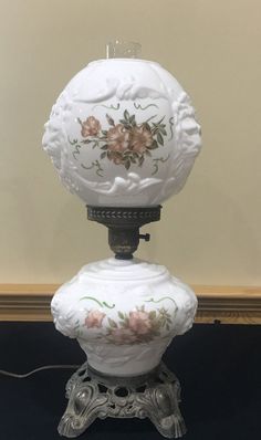 an ornate white lamp with flowers on it