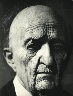 an old black and white photo of a man in a suit with his eyes closed