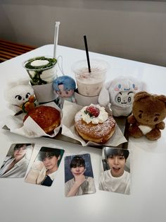 a table topped with pictures and stuffed animals next to food on top of napkins