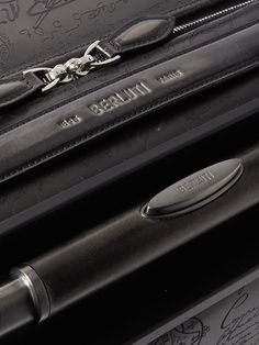 Berluti's 'Scritto' motif was originally hand-calligraphed on its leather goods. This 'Formula 1005' suitcase has been made in Italy from signature Venezia leather and embossed with the iconic lettering. Equipped with an internal zipped compartment and pocket on the front, it's the ideal size for carry-on luggage. Luxury Black Briefcase With Case Included, Luxury Rectangular Case For Business Trips, Luxury Rectangular Cases For Business Trips, Luxury Business Cases With Interior Card Slots, Luxury Cases With Interior Card Slots For Formal Use, Luxury Black Case With Interior Card Slots, Luxury Black Cases With Interior Card Slots, Leather Wash Bag, Leather Suitcase