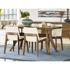 a dining room table with chairs and a blue rug