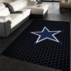 a living room with a white couch and blue star rug on the floor in front of a large window