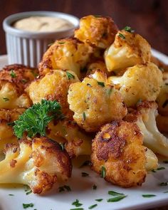 a white plate topped with cauliflower and cheese