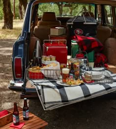 the back end of a car with picnic food and drinks on it, including beer