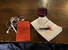 a glass of wine and a notebook on a table