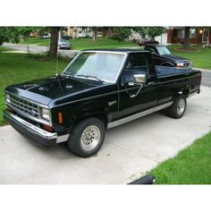 a black pick up truck parked in front of a house