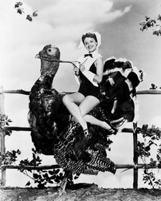 two women sitting on top of a large turkey