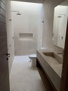 a modern bathroom with two sinks, toilet and shower stall in it's center