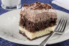 a piece of cake with chocolate frosting on a white plate next to a fork