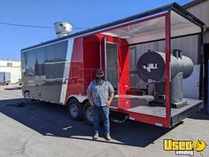 a man standing in front of a red and black food truck with the door open