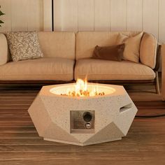 a fire pit sitting on top of a wooden floor next to a couch and table