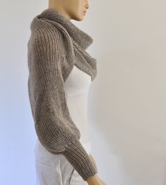 a female mannequin wearing a gray sweater and white pants