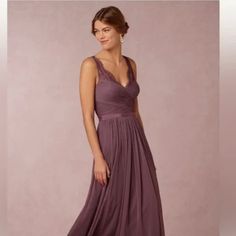 a woman in a long purple dress posing for the camera