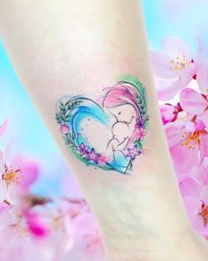 a small tattoo on the ankle of a girl with flowers and a heart shaped frame