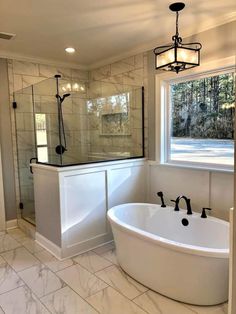 a large white bath tub sitting next to a window