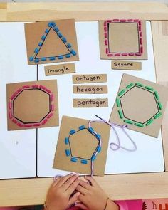 a child is working on an art project with cardboard and stringing pieces that spell out shapes