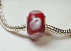 a red and white glass bead on a silver plated chain bracelet or necklace