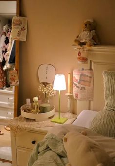 a bed room with a neatly made bed and a teddy bear sitting on the dresser