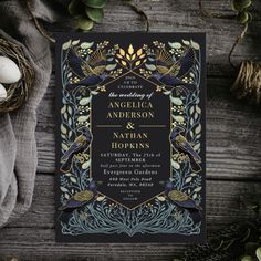 an ornate wedding card with black and gold foil, featuring two birds on the front