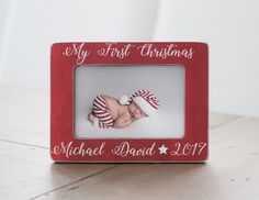 a small red frame with a baby's first christmas photo on the front and bottom