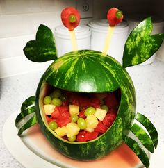 a watermelon shaped like a frog with fruit in it's mouth