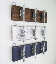 three wooden hooks hang on the wall with metal handles