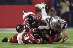 a group of football players colliding on top of each other