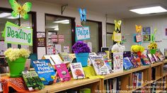 the bookshelves are full of children's books and flowers in vases