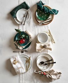 the table is set with dishes and napkins, silverware, and christmas decorations