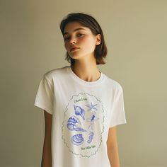 Get ready for sunny days with our soft style t-shirt featuring trendy retro doodles of beach icons like starfish, seashells, a surfer girl and more. This shirt captures the playful and carefree spirit of beach life. Product Features: -Material: Made from 100% ring-spun cotton, this lightweight fabric (4.5 oz/yd² or 153 g/m²) ensures a comfortable wear all year round. -Design: The retro doodles and distressed printing give the t-shirt a unique, vintage appeal that's perfect for beach lovers. Fit: With a classic fit and crew neckline, this shirt offers a clean, versatile style suitable for any occasion, whether casual or semi-formal. -Durability: The shoulders feature twill tape for improved durability, and the ribbed knitting on the collar prevents curling damage. The shirt is designed with Summer White Print T-shirt For Everyday, White Print T-shirt For Summer Everyday Wear, Summer Graphic Print Tops For Everyday, Retro Doodles, Save The Sharks, Siesta Beach, Beach Icon, Beach Tattoo, Surf Tee